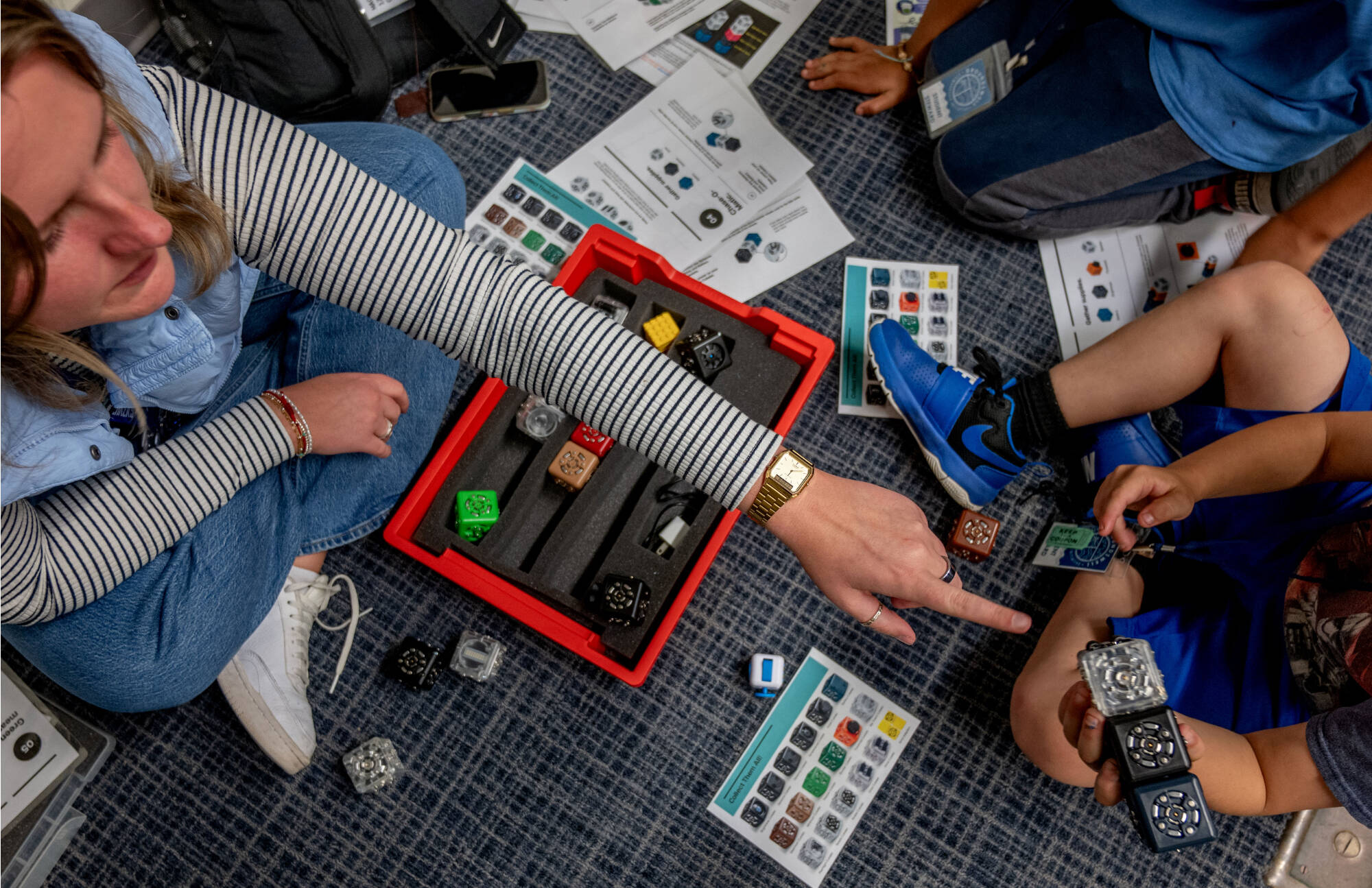 A Coordinator works with students as they build robot blocks during the Groundswell Stewardship Initiative Student Project Showcase at DeVos Center
